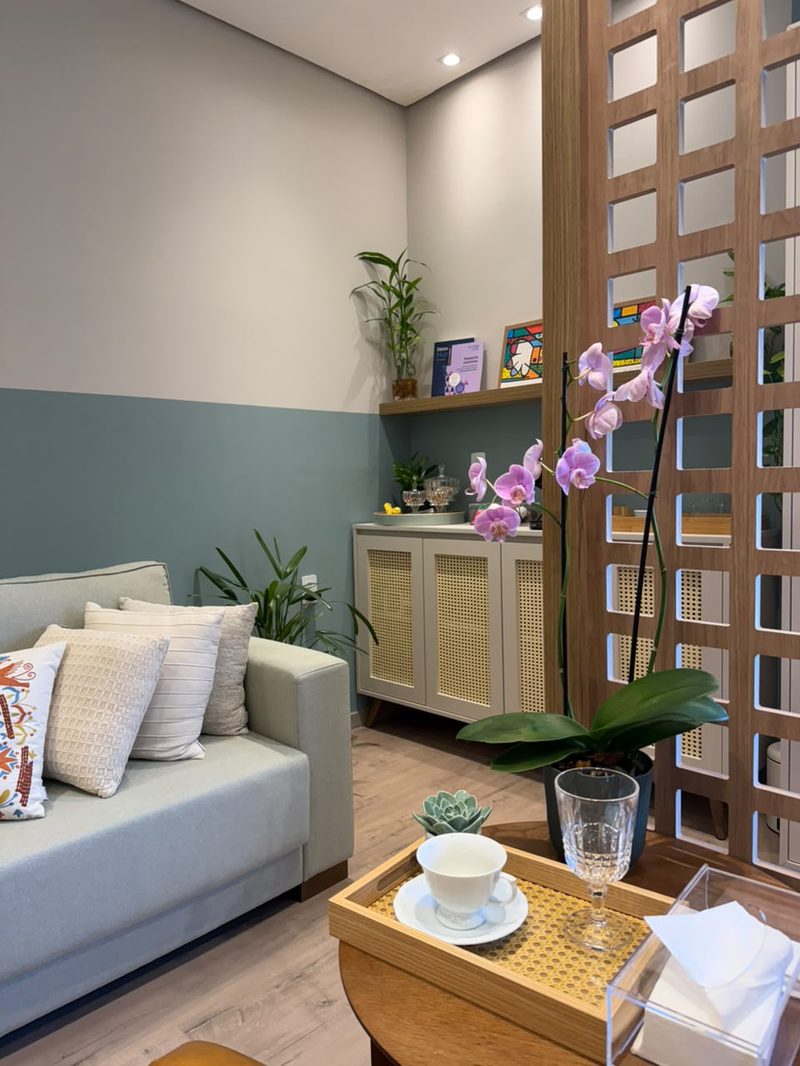Sofá, orquídea e bandeja com xícara no consultório