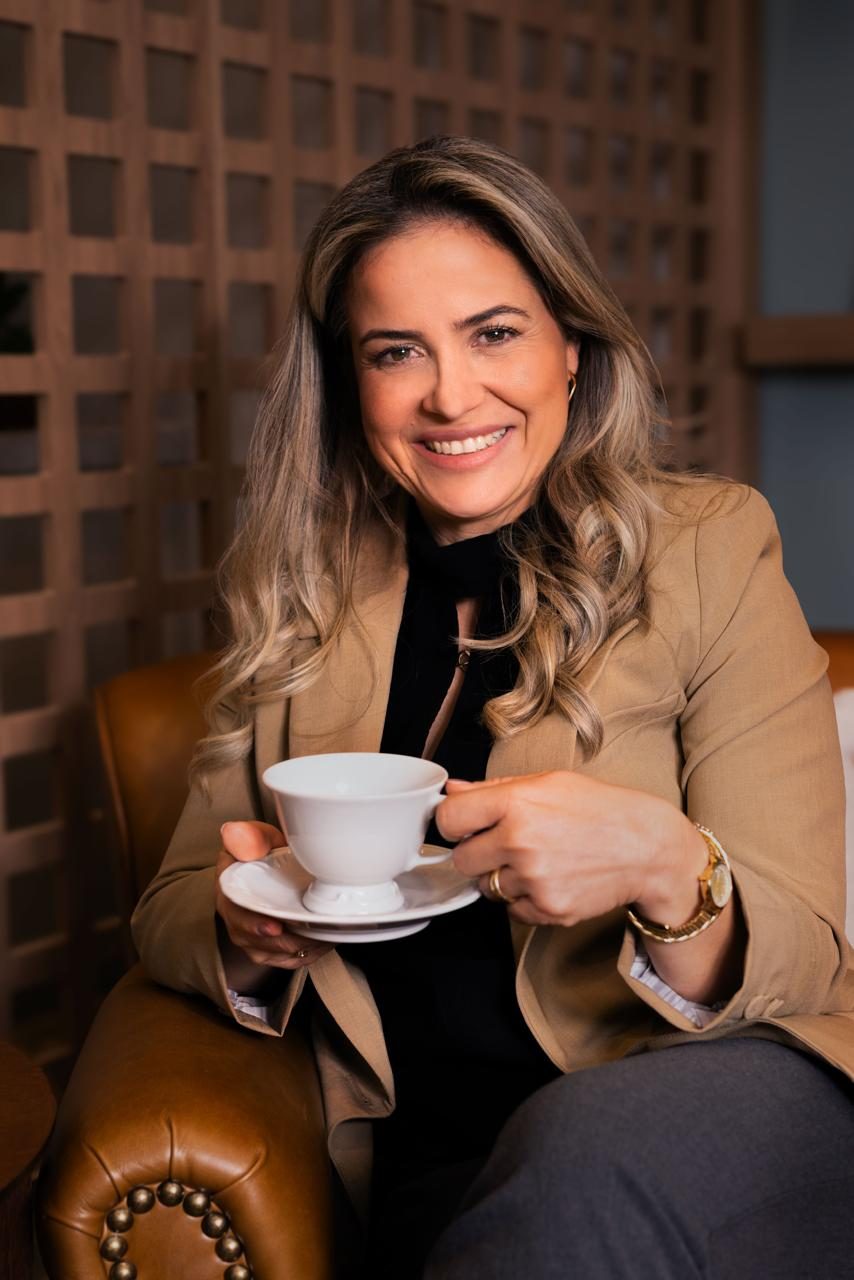 Renata Chmieleski sorrindo, segurando uma xícara de chá